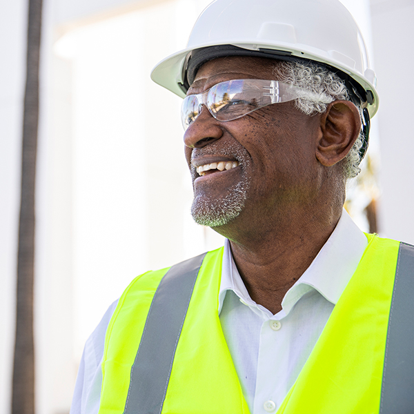 A man wearing safety equipment is smiling.