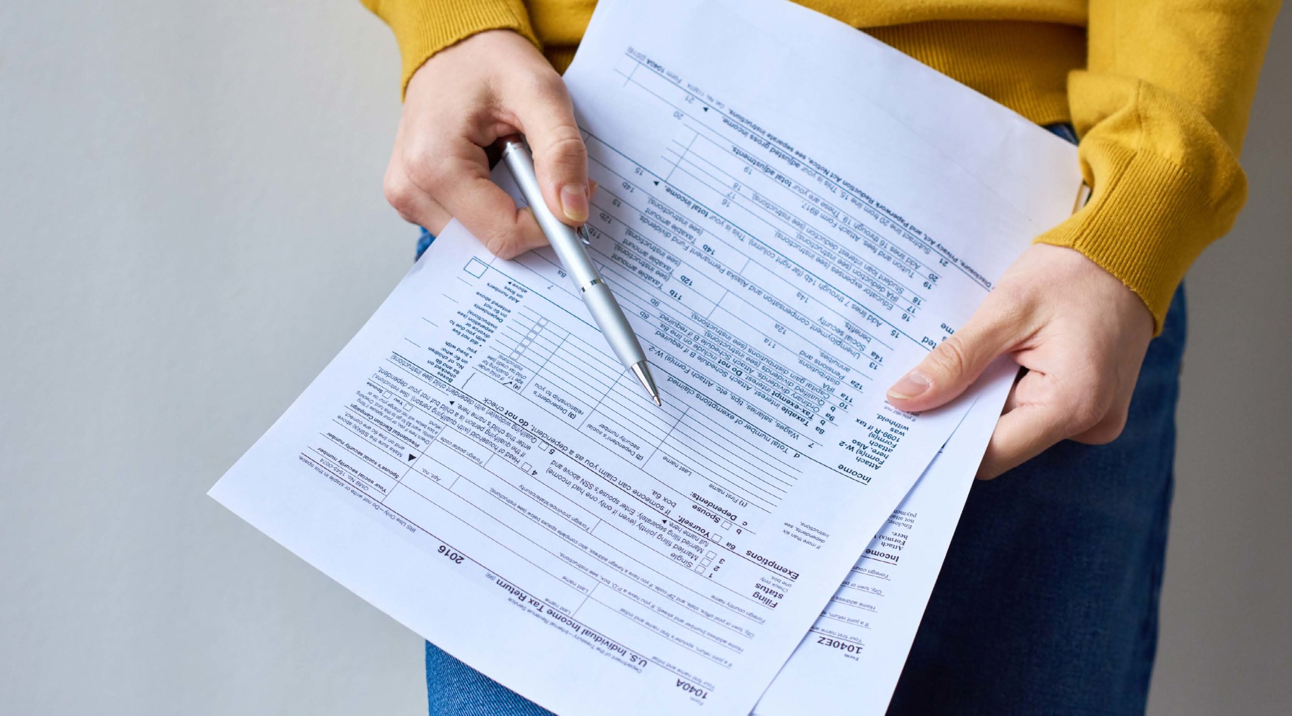 A close-up shot of a person holding tax papers.