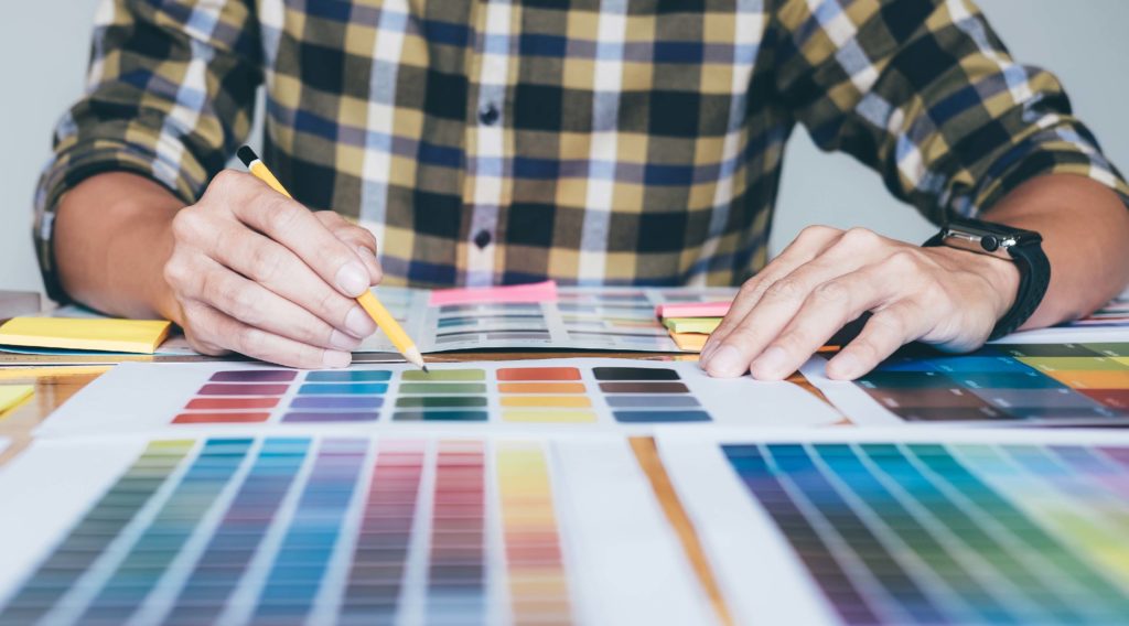 A close-up shot of a man consulting color swatches for a marketing campaign.