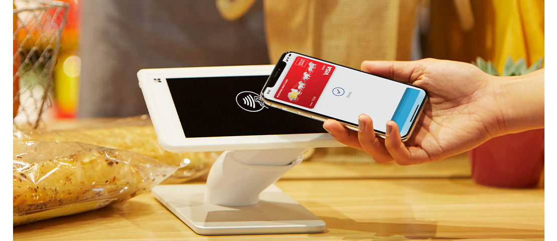A shopper pays using a CLOVER terminal and their smart phone.