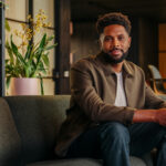 A business man sitting on a couch in his office.