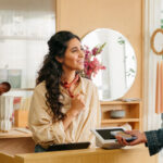Customer pays with a mobile device at a business checkout counter