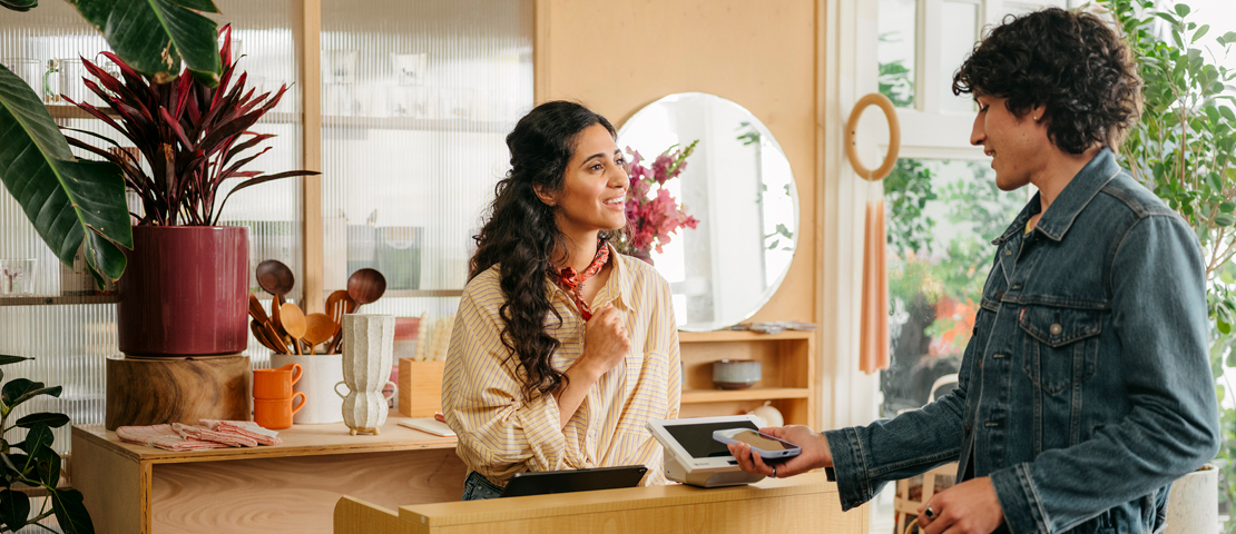 Customer pays with a mobile device at a business checkout counter